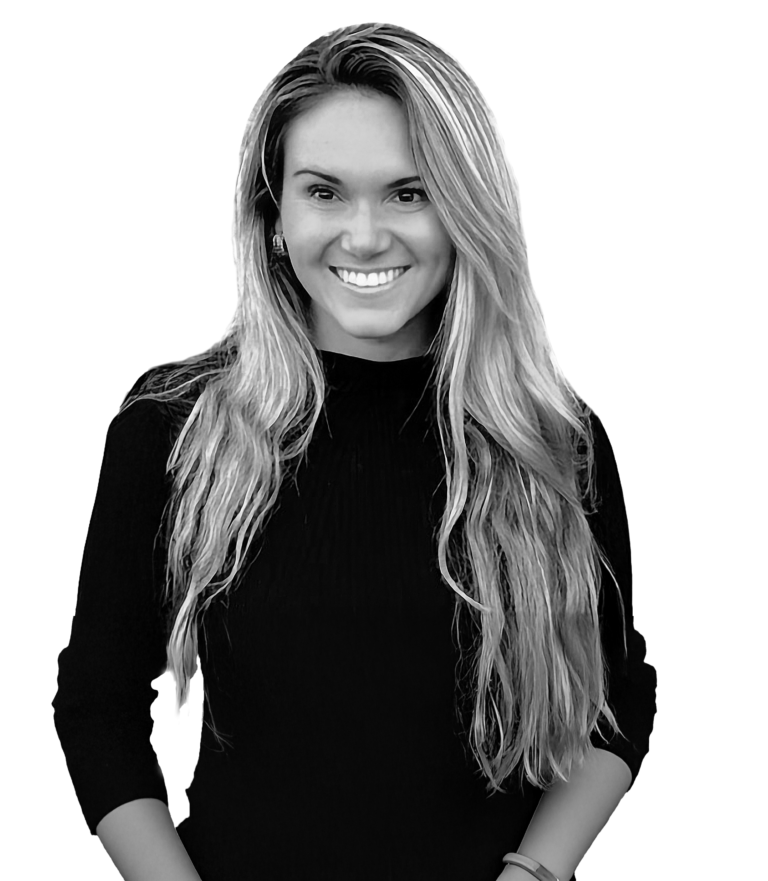 Black and white portrait of a smiling woman with long, wavy hair wearing a dark top.